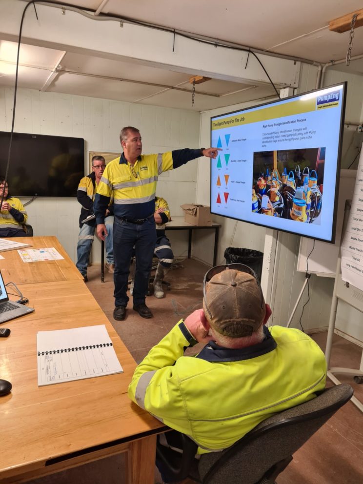 PumpEng worker demonstrating the PumpEng Triangle Guide for mining pump identification