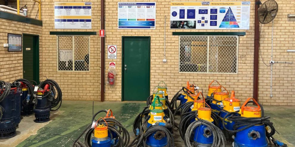 Multiple underground mine dewatering pumps sitting on a concrete warehouse floor at PumpEng's Kalgoorlie branch