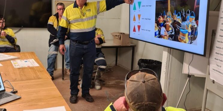 PumpEng worker demonstrating the PumpEng Triangle Guide for mining pump identification